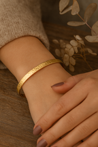 Bracelet jonc doré martelé MoonRose, finition brillante et texture martelée, porté au poignet, style élégant et moderne.